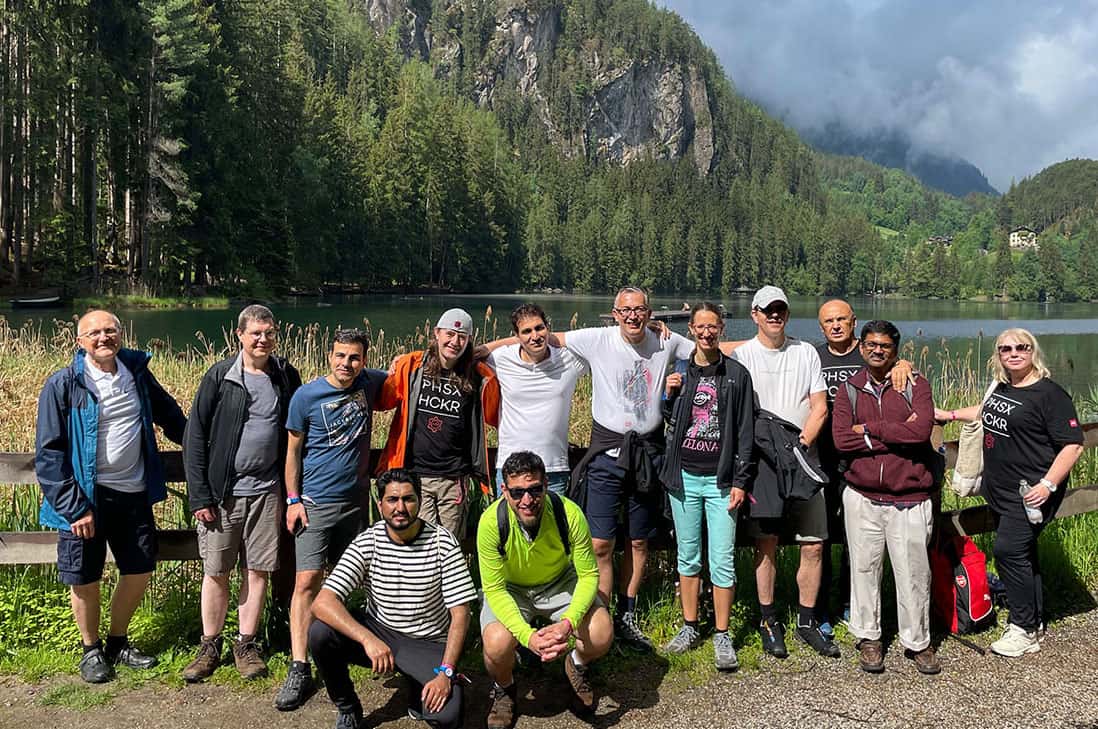 a group of people standing next to each other near a lake