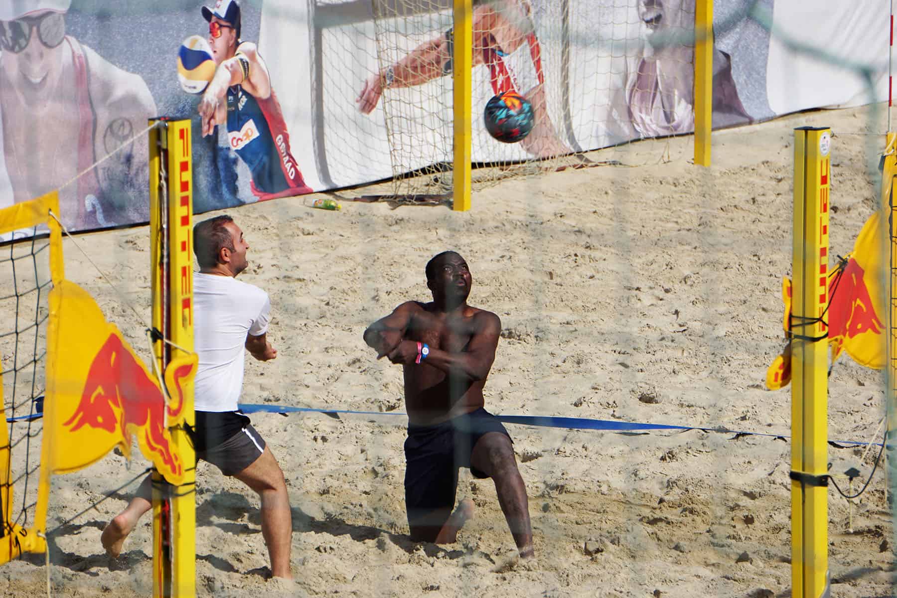 a couple of men playing a game of volleyball