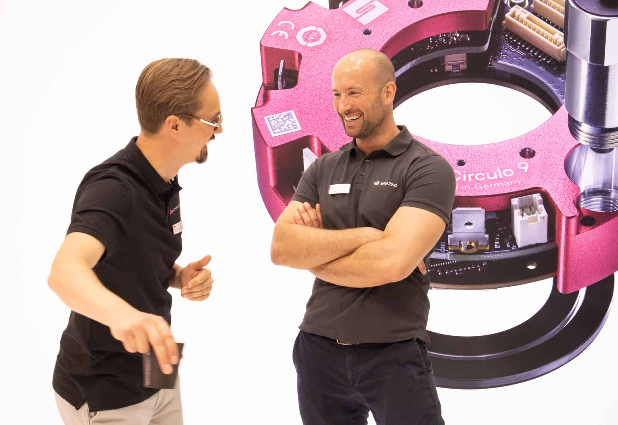 two men standing next to each other and talking