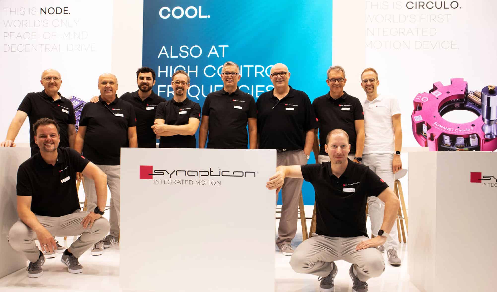 a group of men standing next to each other in front of a sign