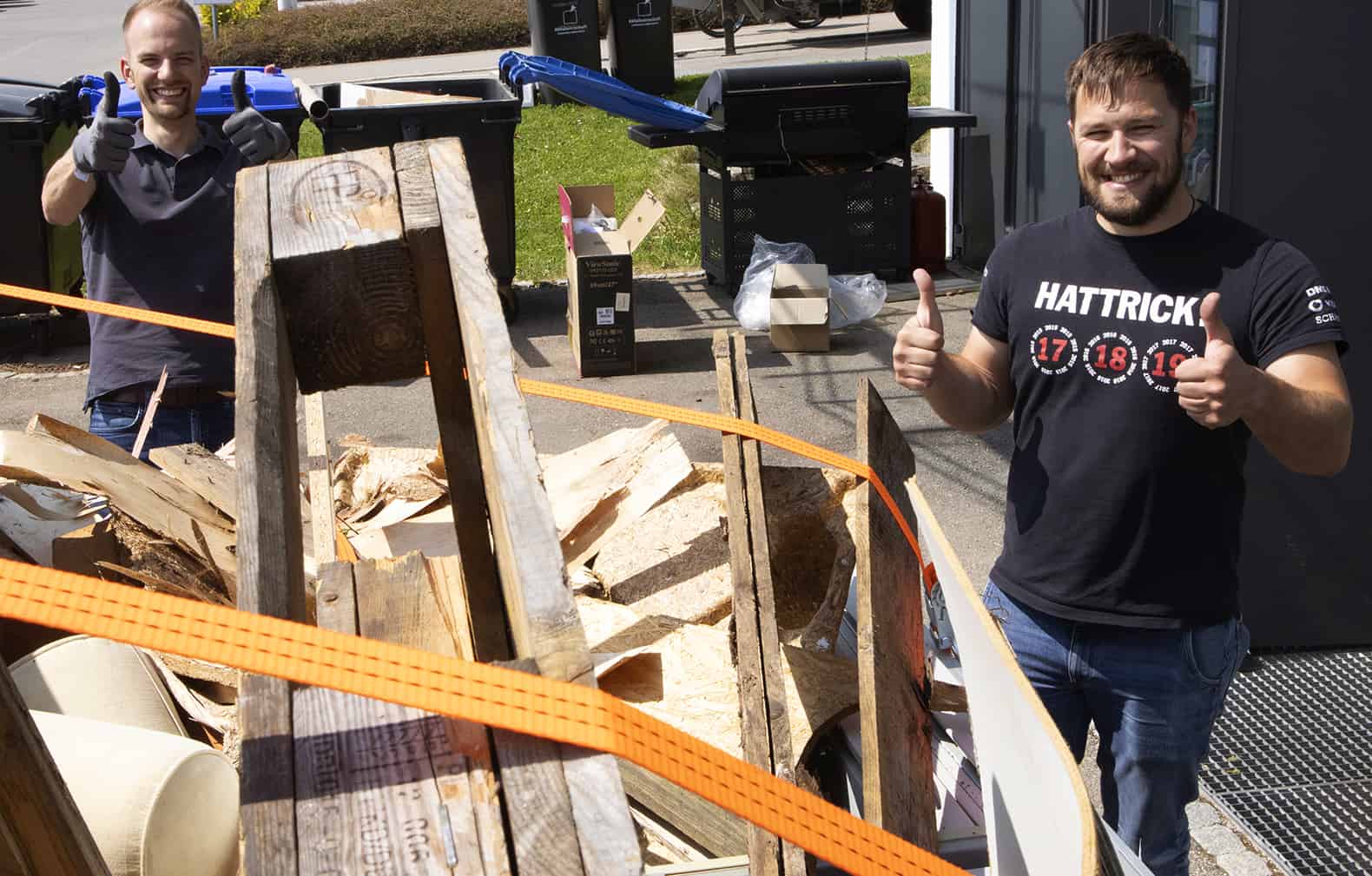 a man giving a thumbs up next to a pile of wood