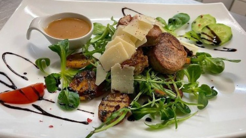 Fleischgerichte auf Feldsalat mit Sauce