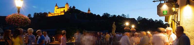 Menschen vor beleuchtetem Schloss