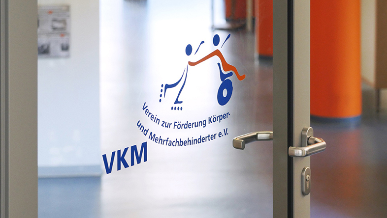 Logo des VKM e.V. an einer Glastür