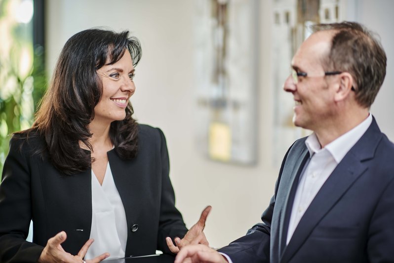 Zwei Geschäftspersonen führen ein Gespräch in einem modernen Büro
