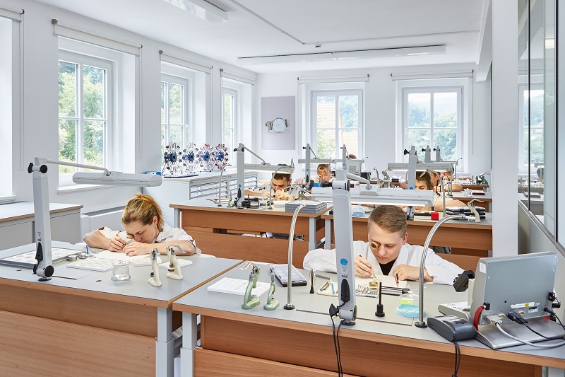 Abteilung für Uhrenmontage mit Mitarbeitern an Werkbänken