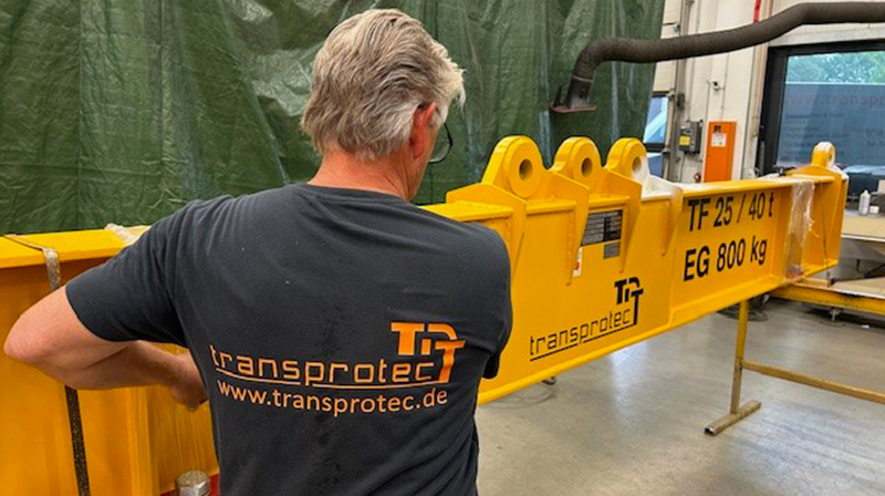 Mitarbeiter bei der Arbeit mit gelber Transportausrüstung in der Werkstatt