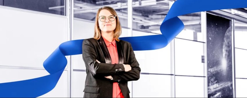 Frau in Businesskleidung in modernem Bürogebäude mit blauem Design-Element