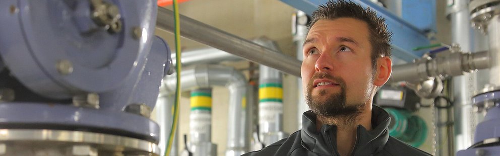 Mitarbeiter inspiziert technische Anlagen in einer Produktionsstätte