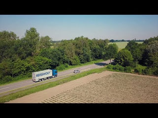 Breisgau-Lastwagen auf Landstraße zwischen Feldern und Bäumen