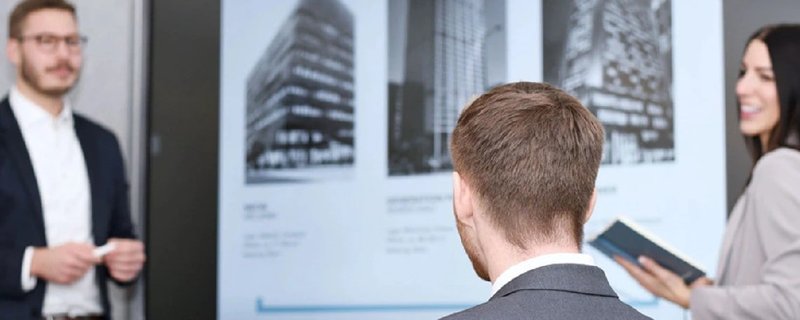 Team diskutiert Immobilienprojekte an Wanddarstellung von Hochhäusern