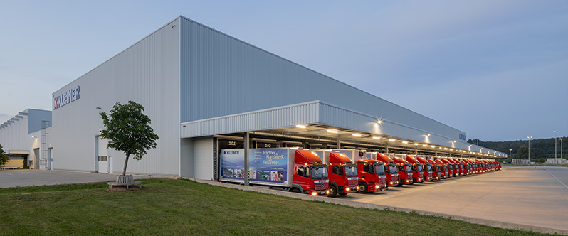 Lagerhalle mit Flotte roter Lastkraftwagen in einer Logistikanlage