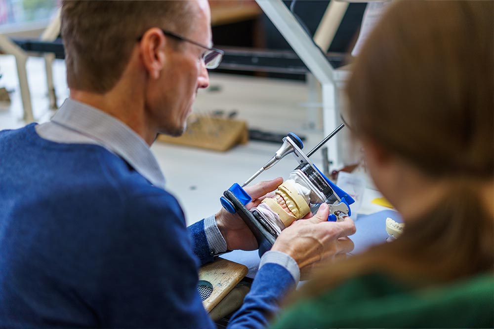 Zahntechniker prüft ein Modell im Artikulator