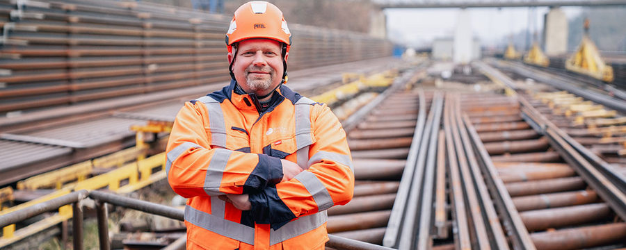 Arbeiter in Schutzkleidung auf Baustelle mit Gleisanlage