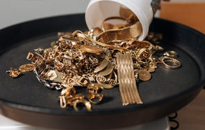 Goldschmuck und Edelmetalle auf einer schwarzen Schale