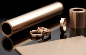 Metallische Rohre und Ringe aus Kupfer oder Messing auf grauem Untergrund