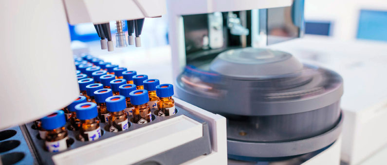 Laborausstattung mit blauen Probenbehältern und Zentrifuge in einem wissenschaftlichen Labor
