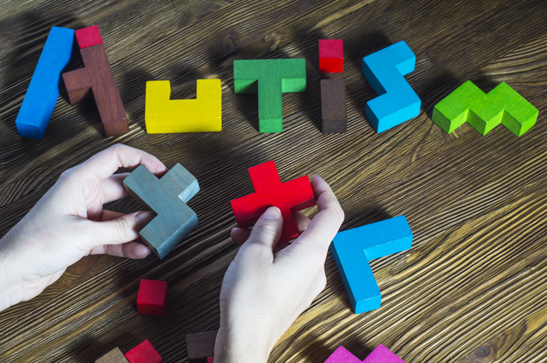 Buchstaben für AUTISM aus farbigen Teilen