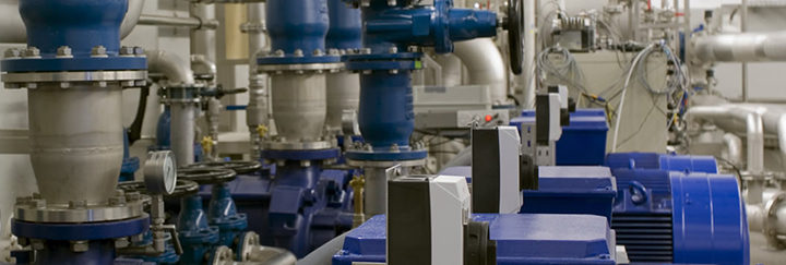 Blaue Ventile und Pumpen mit Rohrleitungen in einer industriellen Produktionsanlage