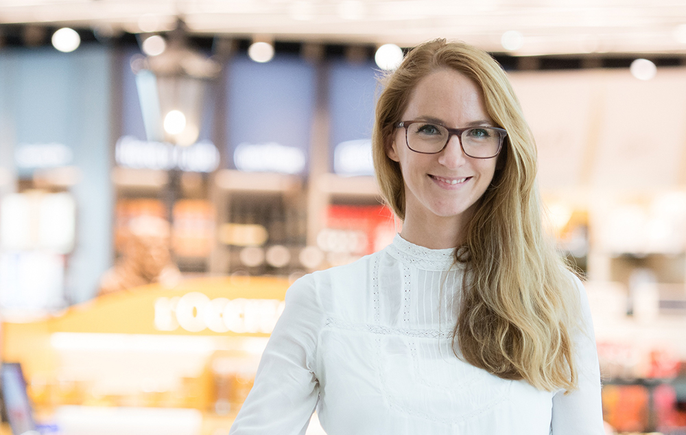 Porträt einer lächelnden Frau mit Brille und heller Bluse