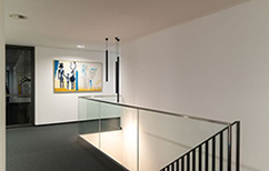 Moderner Flur mit Glasgeländer und Wandbild