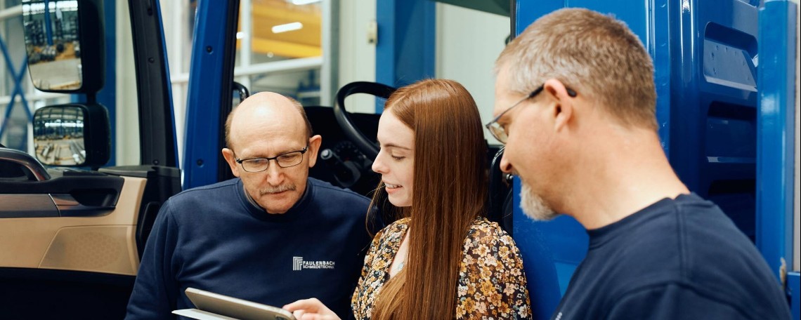 Team bespricht Tablet in der Werkstatt