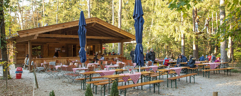 Biergarten mit Holzhütte im Wald
